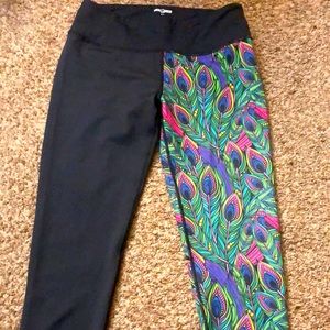 Feed me fight me peacock leggings. Half black and half peacock design.
